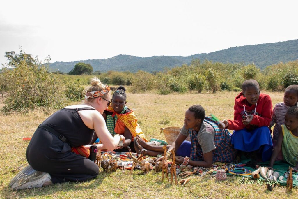 Empowering local communities: An Ease My Safari guest contributes to sustainable tourism by supporting local businesses and purchasing locally made crafts during a Cultural Village visit in Maasai Mara